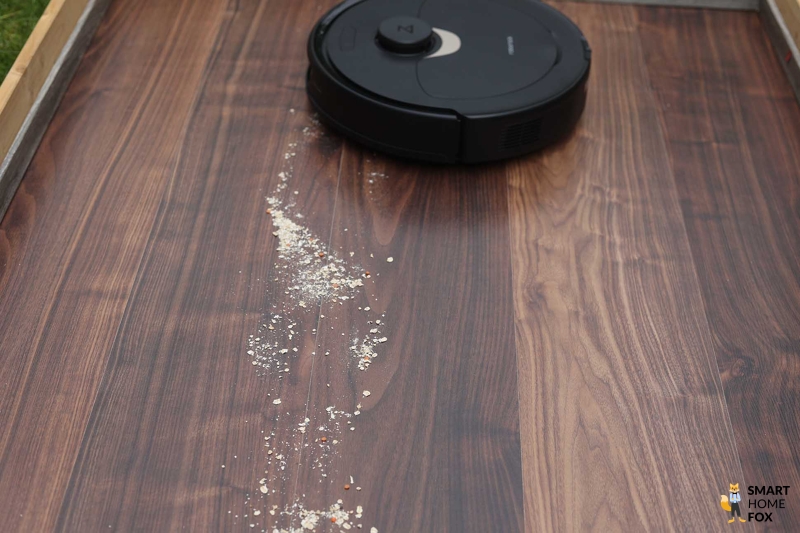 Der Roborock Q Revo saugt Haferflocken beim Saugtest auf dem Laminat.